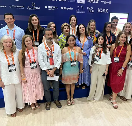 l grupo posa frente a un backing azul con los logotipos de organizaciones participantes y empresas del sector tecnológico. Los asistentes llevan acreditaciones del evento ANDICOM 2026 y visten semiformales reflejando un espacio de diálogo y cooperación sobre transformación digital.