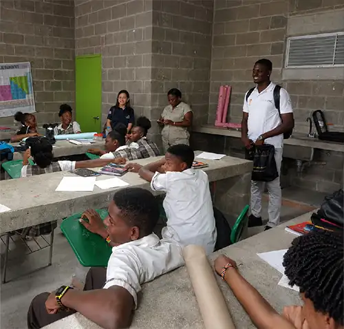 Un grupo de estudiantes participa en una sesión de formación dentro de un aula con mesas de trabajo de concreto